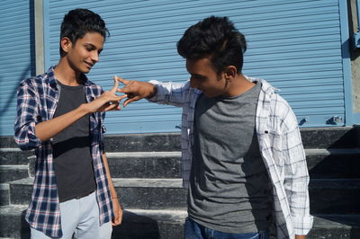 Side view of smiling young woman using mobile phone