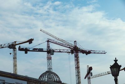 Low angle view of cranes against sky