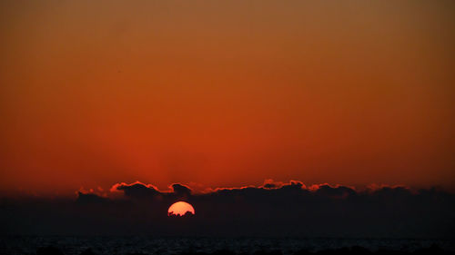 Silhouette mountain against orange sky