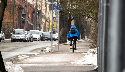 Rear view of woman standing on road