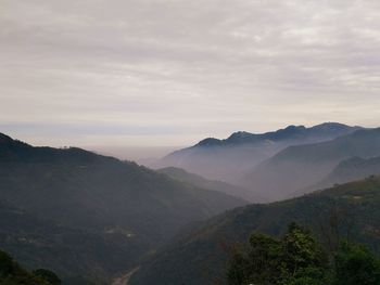 Scenic view of mountains against cloudy sky