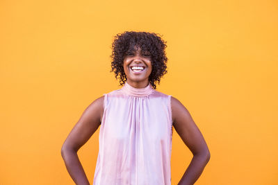 Portrait of smiling woman against yellow background