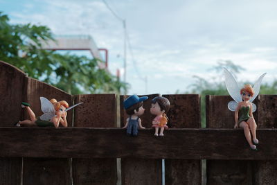 Boy and stuffed toy against sky