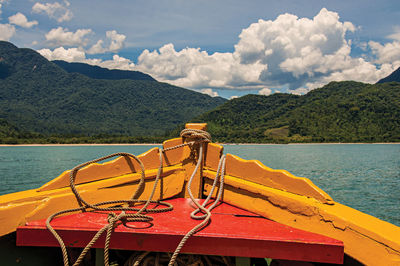 View of colorful boat bow with sea, forest and sunny sky in background near paraty, brazil.