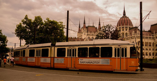 Train on railroad tracks in city against sky