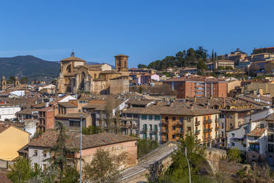 Buildings in city against clear blue sky