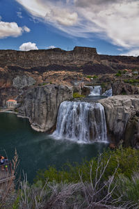 Scenic view of waterfall against sky