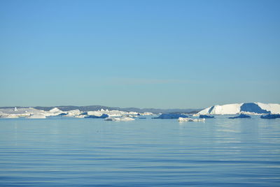 Scenic view of frozen lake against clear blue sky