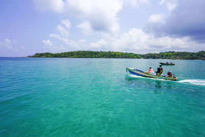 People in sea against sky