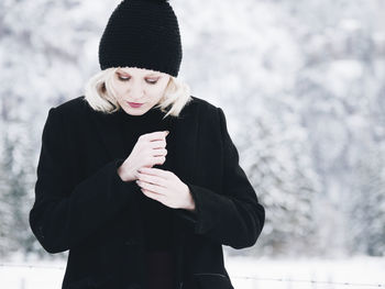 Mid adult woman standing on snow covered mountain