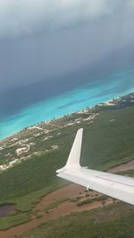 Airplane flying over sea against sky