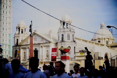 People at temple against sky in city