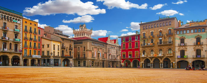 Buildings in town against cloudy sky