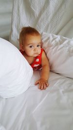 Portrait of cute baby lying on bed at home