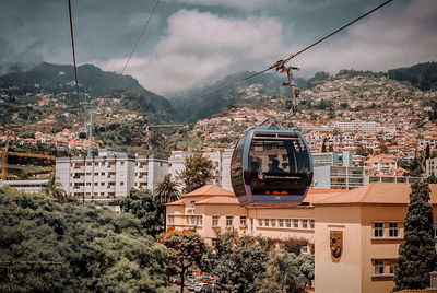 Overhead cable car and buildings against sky