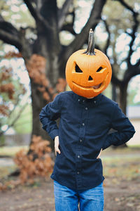 Person having fun with a carved pumpkin head