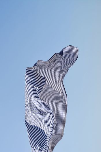 Low angle view of fabric against clear blue sky