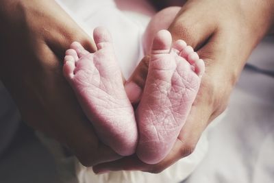 Close-up of hands holding newborn