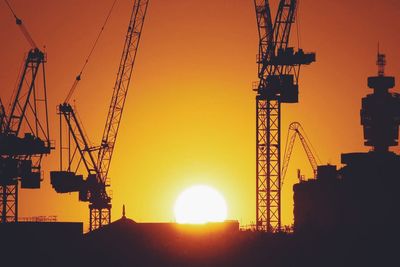 Low angle view of crane against sky during sunset