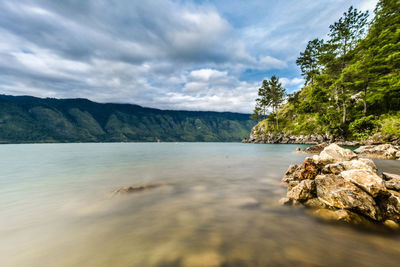 Scenic view of sea and mountains against sky