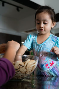 Kids in the kitchen, making cakes together.