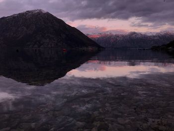 Scenic view of lake by mountain against sky