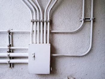Close-up of pipes against white wall
