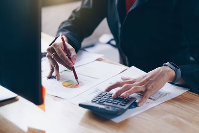 Midsection of businesswoman working at desk in office