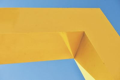 Low angle view of yellow built structure against blue sky