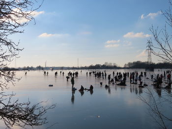 Group of people on calm lake at sunset