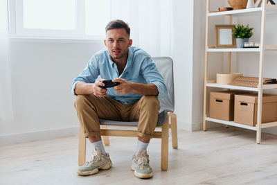 Young man playing video game at home