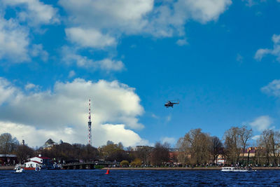 Airplane flying over river against sky