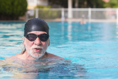 Portrait of shirtless man swimming in pool