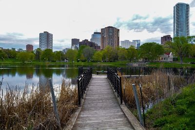 Footbridge over river with buildings in background