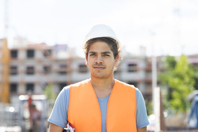 Young construction engineer with helmet working outside