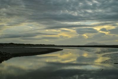 Scenic view of calm lake against cloudy sky