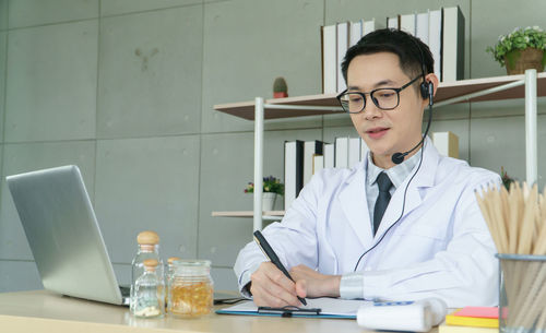 Man using mobile phone while sitting on table