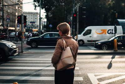 Rear view of man crossing road