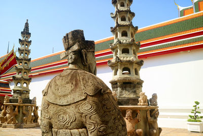 Chinese guardian statue and pagoda at wat pho buddhist temple, bangkok old city, thailand