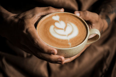 Cropped image of hand holding coffee cup