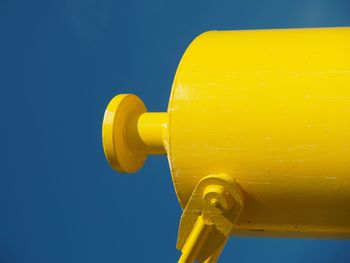 Yellow metal pipe against clear blue sky