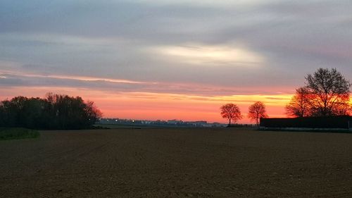 Scenic view of field against romantic sky at sunset