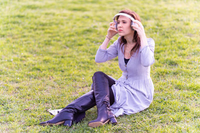 Young woman sitting on grass in field