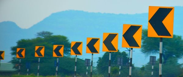 Close-up of yellow sign against sky