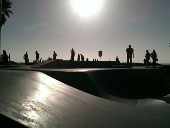 Silhouette of people walking against clear sky