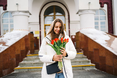 Girl with a bouquet of tulips at the train station, international women's day
