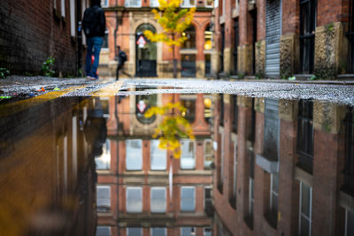 Reflection of building in puddle on street