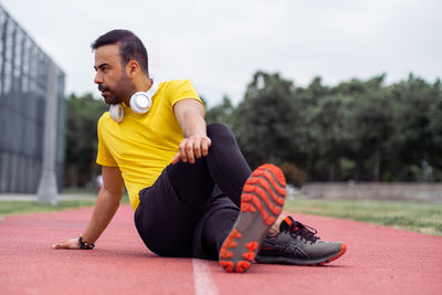 Portrait of young woman exercising on field