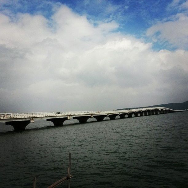 water, connection, sky, bridge - man made structure, built structure, cloud - sky, waterfront, bridge, architecture, river, sea, cloudy, engineering, cloud, tranquility, rippled, transportation, nature, tranquil scene, scenics