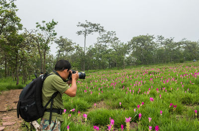 Woman photographing on field